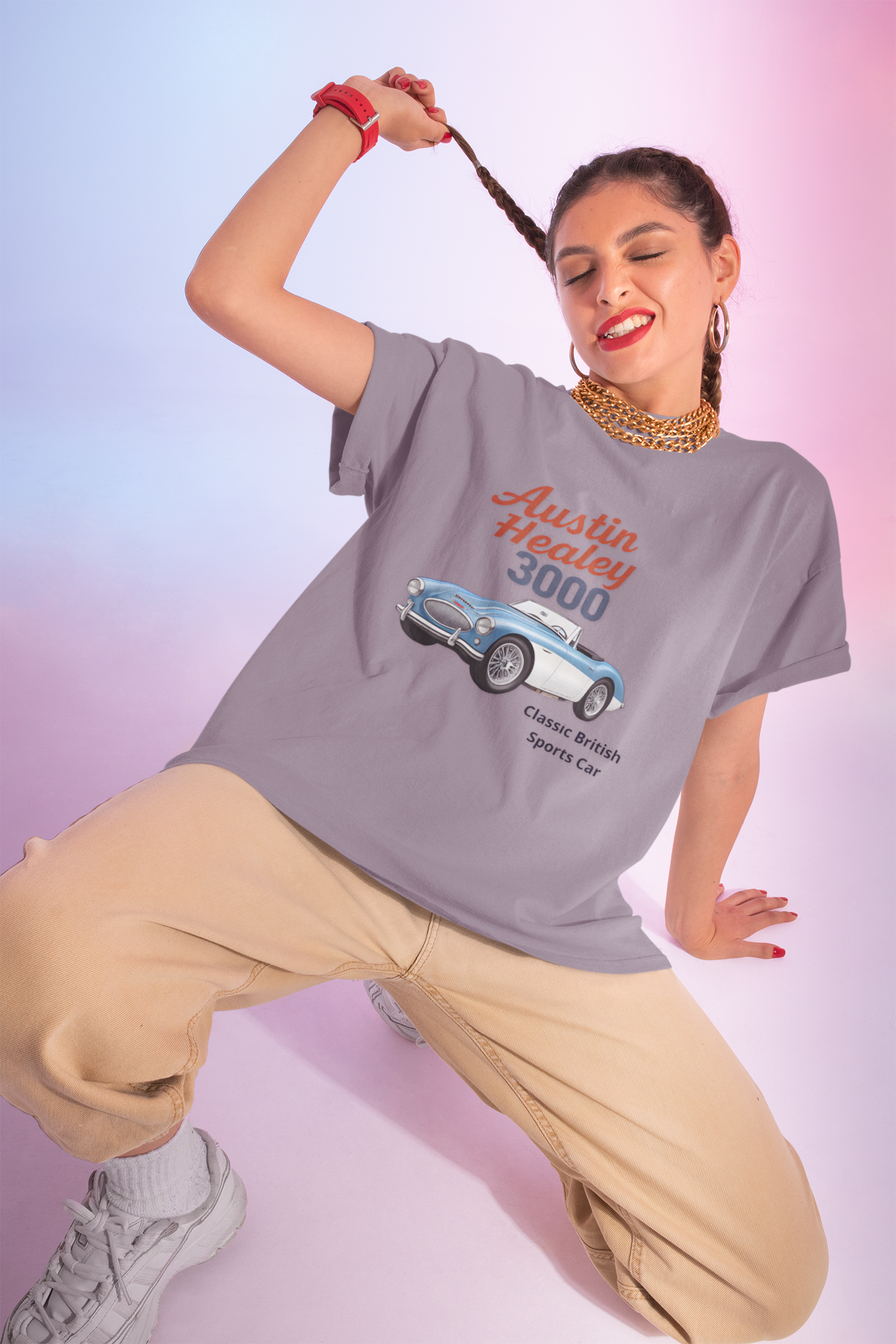 Woman wearing a gray t-shirt with an Austin Healey 3000 graphic on a gradient background